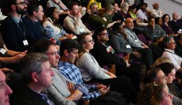 People seating in a tiered auditorium 