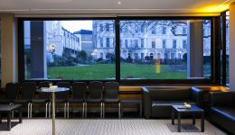 A picture of a room with a large window overlooking a green garden