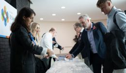four people at a registration desk collecting event badges