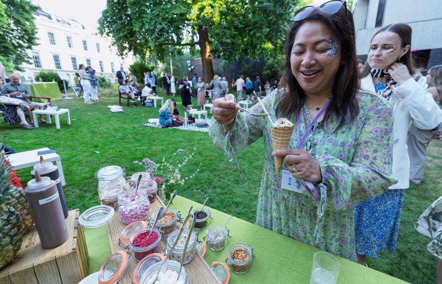 A woman with an ice-cream cone and toppings in a garden